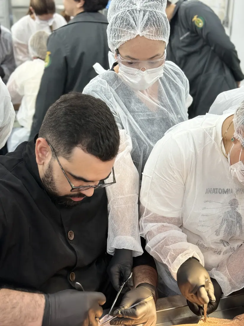 Professor demonstrando a técnica com pinça e bisturi